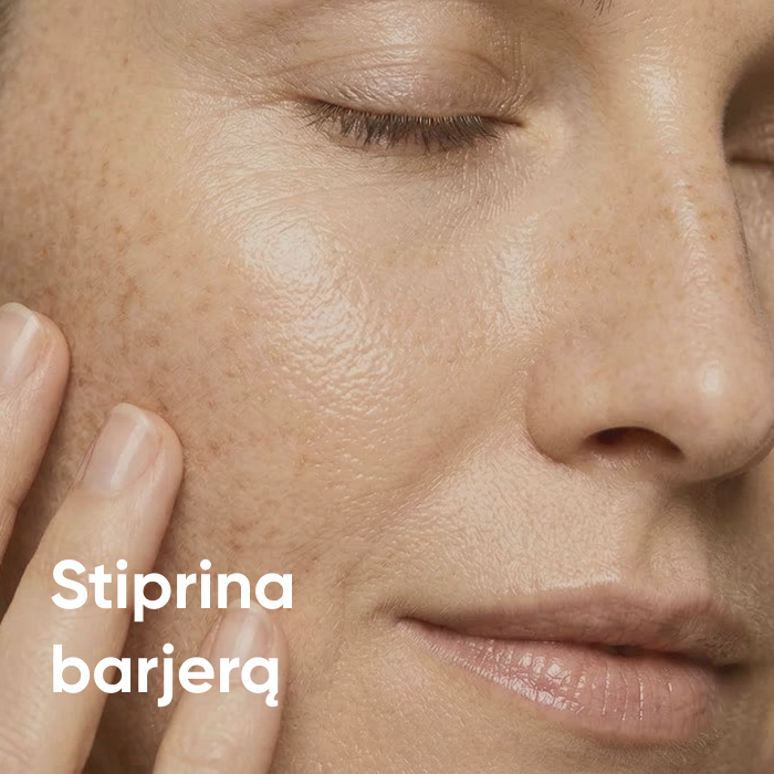 Moteris su užmerktomis akimis švelniai liečia skruostą – stiprina odos barjerą.
